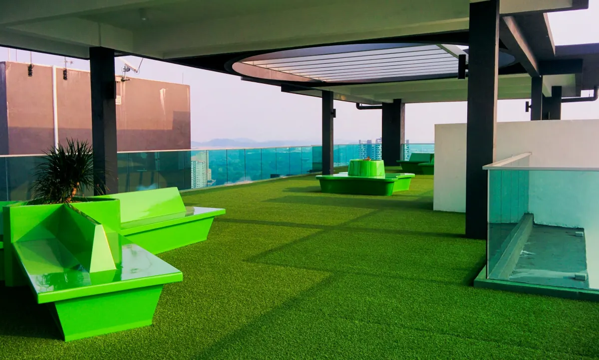 Terraza de uso comercial con césped sintético y mobiliario fijo